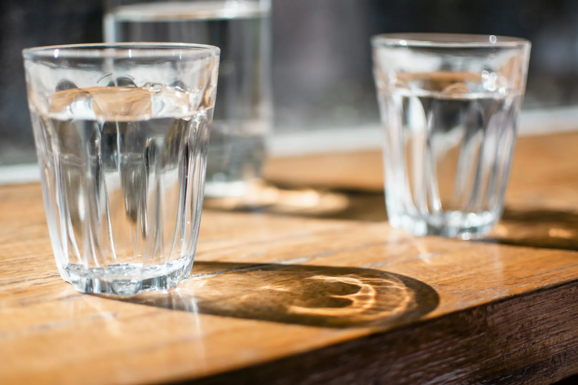 Better water at home in Aliso Viejo Glasses of clear drinking water on a sunlit wooden table