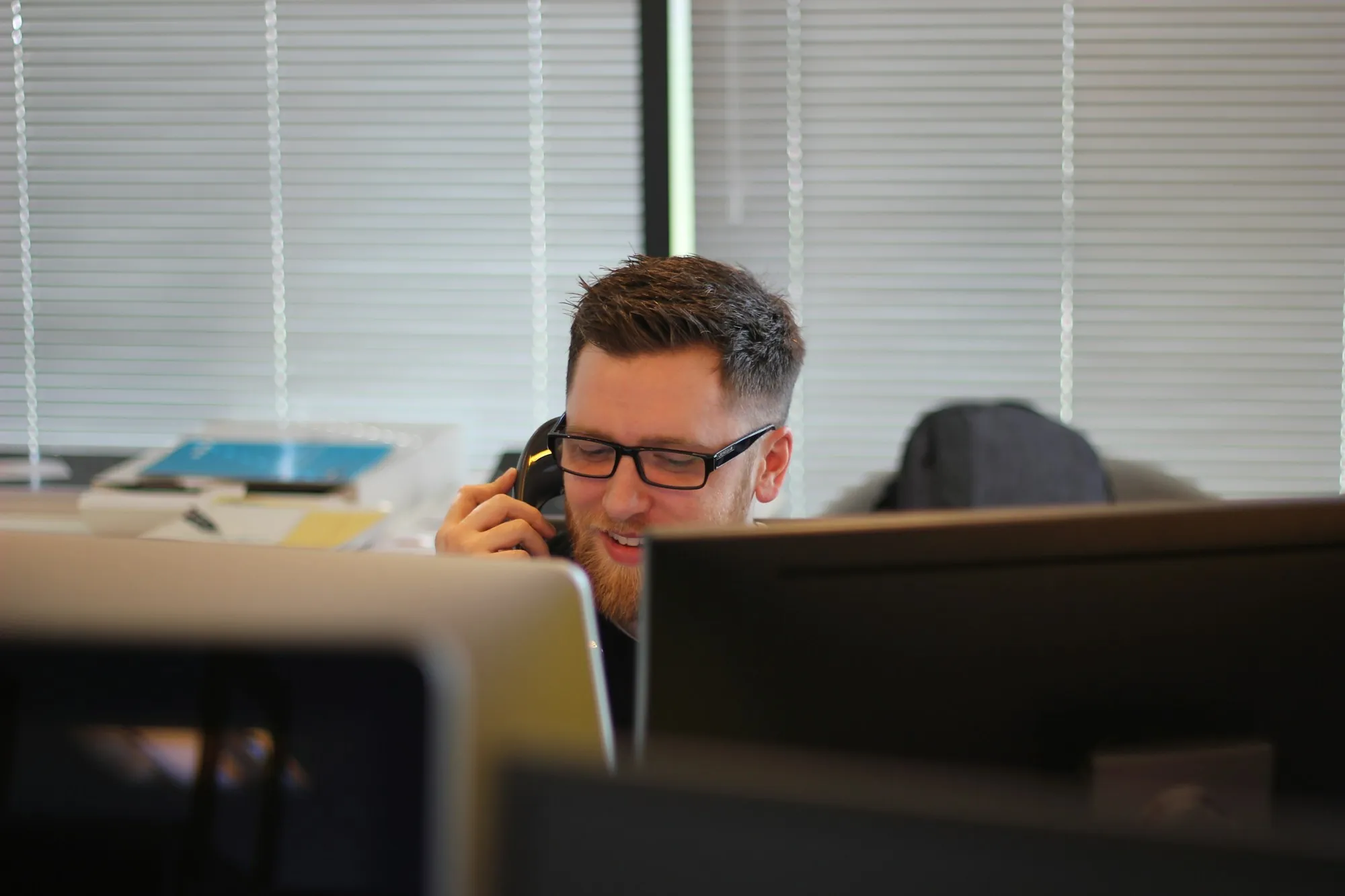 Man talking on a desk phone in an office