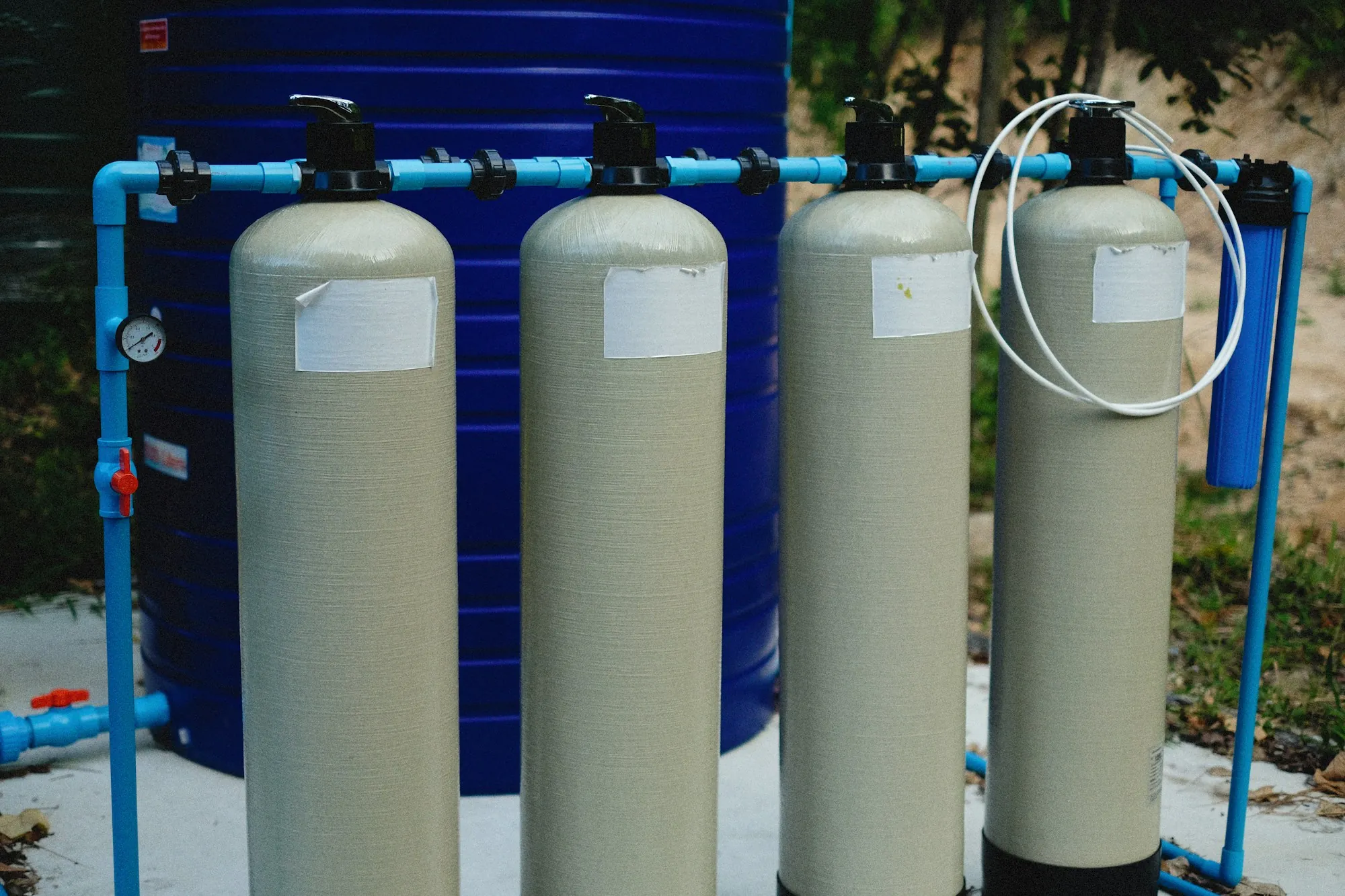 Row of water treatment tanks connected by blue piping
